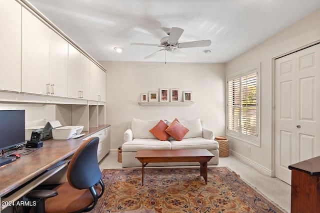 carpeted office space featuring ceiling fan