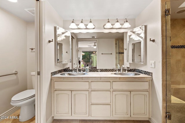 bathroom featuring vanity, tile patterned flooring, toilet, and an enclosed shower