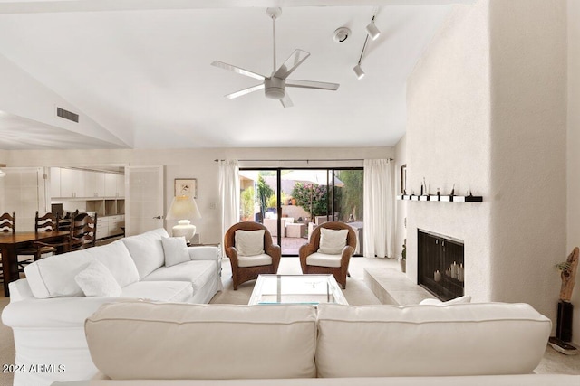 living room featuring rail lighting, a large fireplace, high vaulted ceiling, and ceiling fan