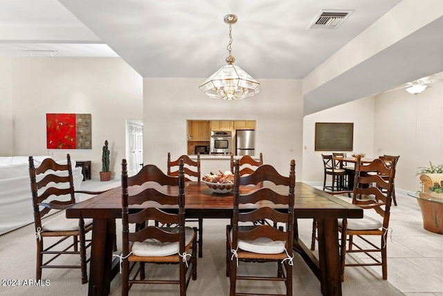 tiled dining room featuring a notable chandelier