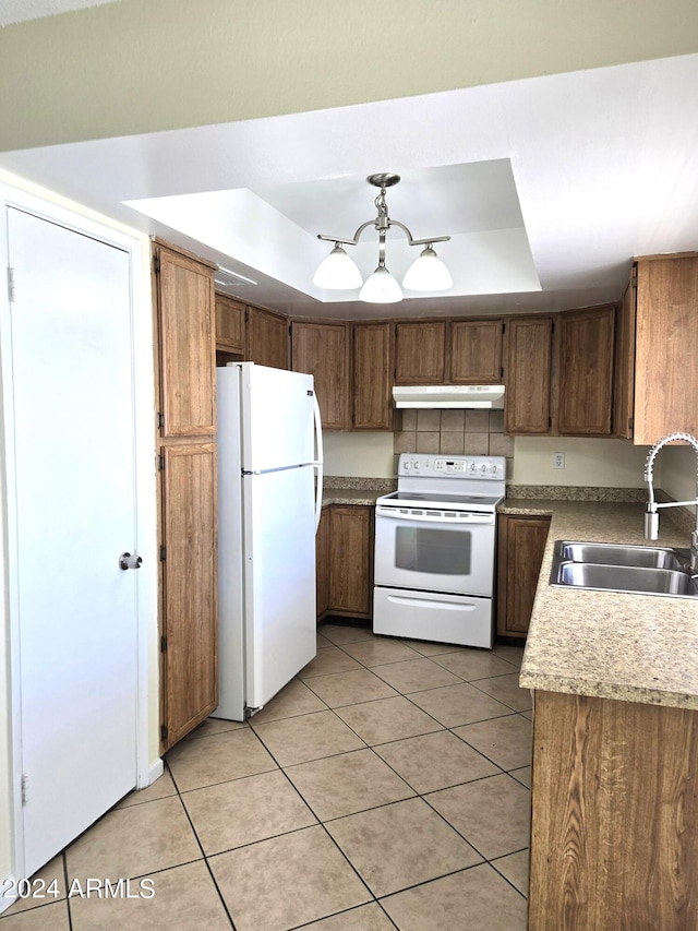 kitchen with light tile patterned floors, sink, white appliances, and a raised ceiling