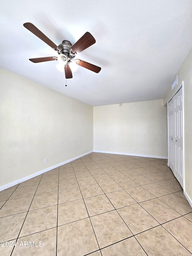 empty room with light tile patterned floors and ceiling fan