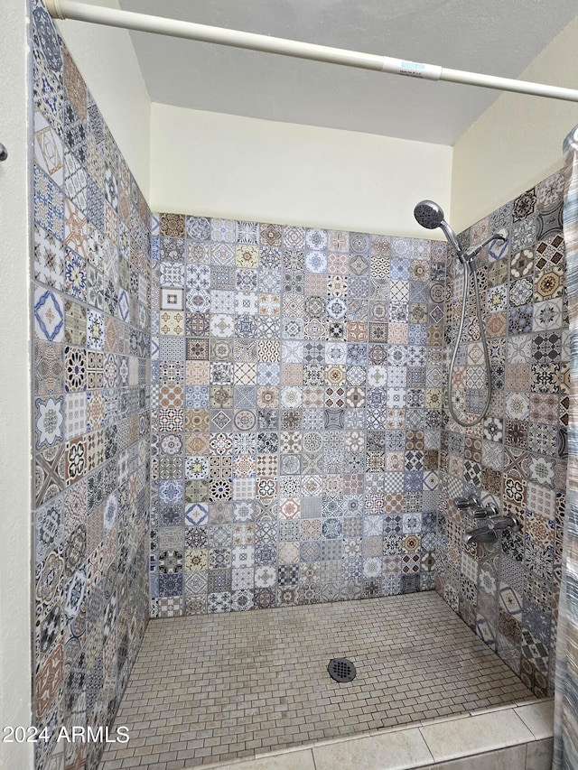 bathroom with tile patterned floors and tiled shower