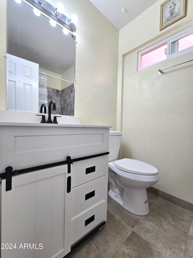 bathroom with toilet, a shower with curtain, vanity, and tile patterned flooring