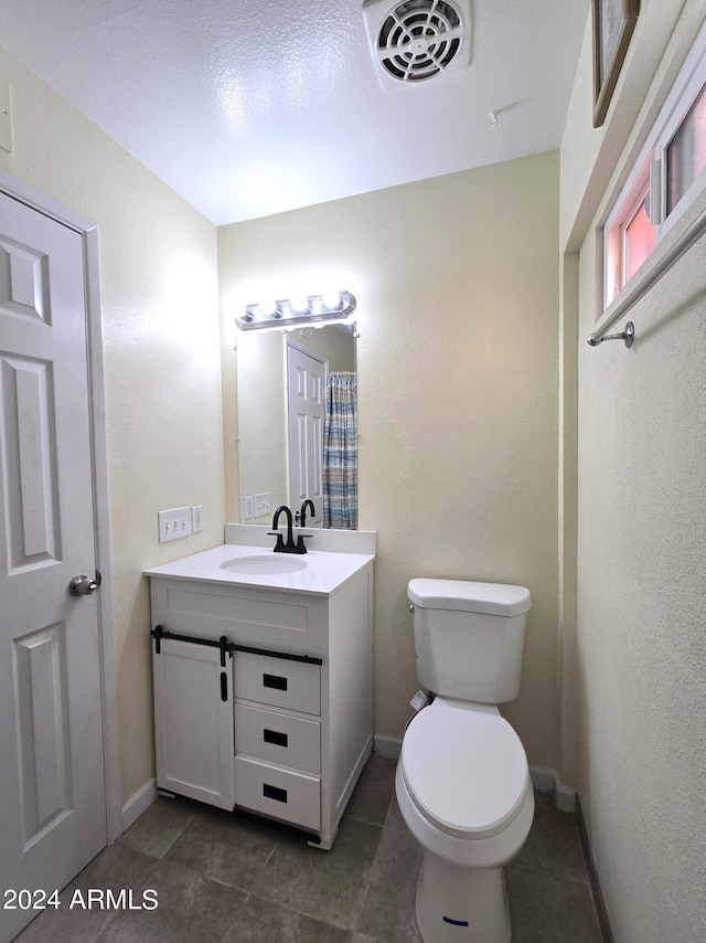 bathroom with vanity, toilet, and tile patterned floors