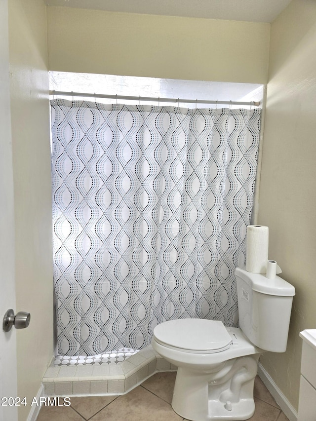 bathroom featuring toilet, a shower with curtain, vanity, and tile patterned floors