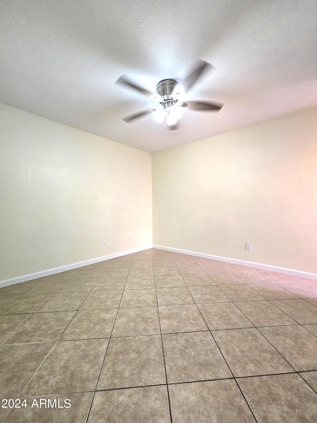 empty room with tile patterned flooring, a textured ceiling, and ceiling fan