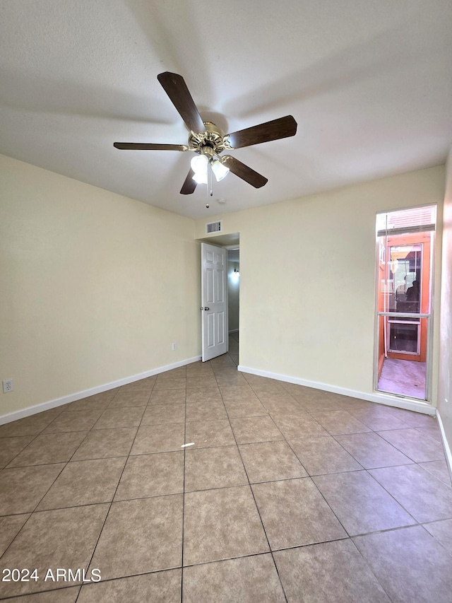 unfurnished room featuring light tile patterned floors and ceiling fan