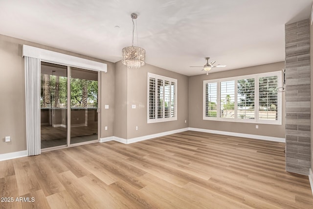 4805 N Woodmere Fairway Unit 1002, Scottsdale, AZ 85251 - empty room featuring plenty of natural light, ceiling fan, a chandelier, and light wood-style floors