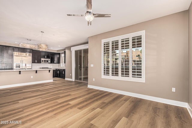 4805 N Woodmere Fairway Unit 1002, Scottsdale, AZ 85251 - unfurnished living room featuring a ceiling fan, wood finished floors, and recessed lighting