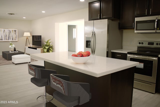 3208 W Bloomfield Rd, Phoenix, AZ 85029 - kitchen featuring stainless steel appliances, a breakfast bar, light wood-style floors, light countertops, and recessed lighting