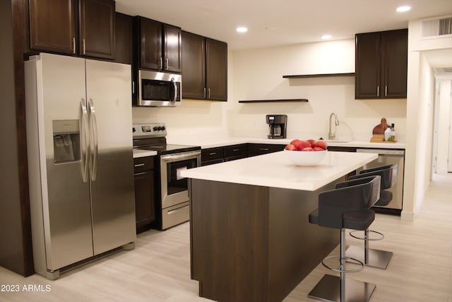 3208 W Bloomfield Rd, Phoenix, AZ 85029 - kitchen featuring stainless steel appliances, a breakfast bar area, light wood-style flooring, light countertops, and recessed lighting