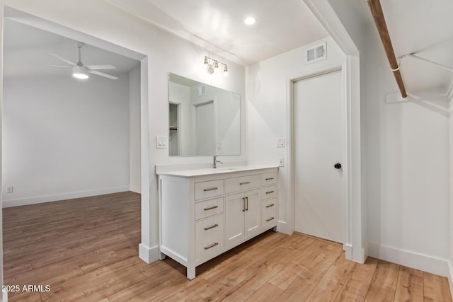 bathroom with wood finished floors, ceiling fan, vanity, and baseboards