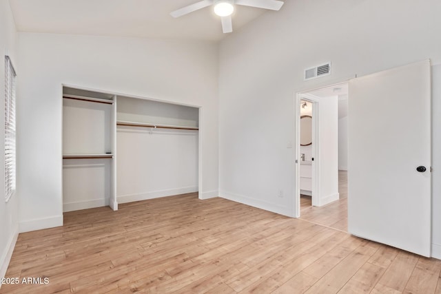 unfurnished bedroom featuring wood finished floors, baseboards, a ceiling fan, a closet, and lofted ceiling