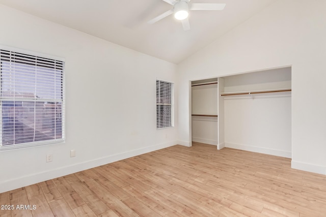 unfurnished bedroom with wood finished floors, lofted ceiling, baseboards, a ceiling fan, and a closet