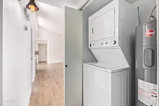 washroom featuring estacked washer and dryer, water heater, light wood-type flooring, and baseboards