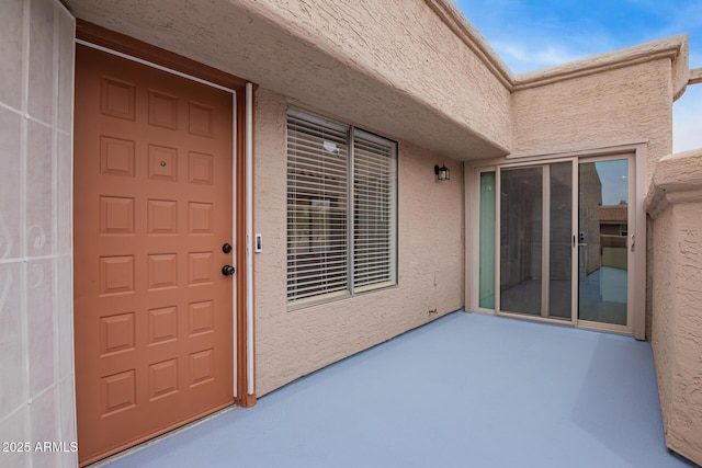 doorway to property with stucco siding and a patio