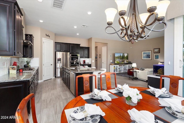 dining area with sink and an inviting chandelier