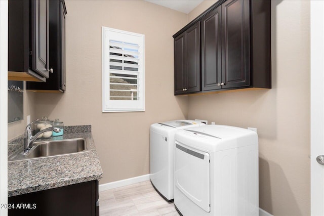 clothes washing area featuring cabinets, separate washer and dryer, and sink