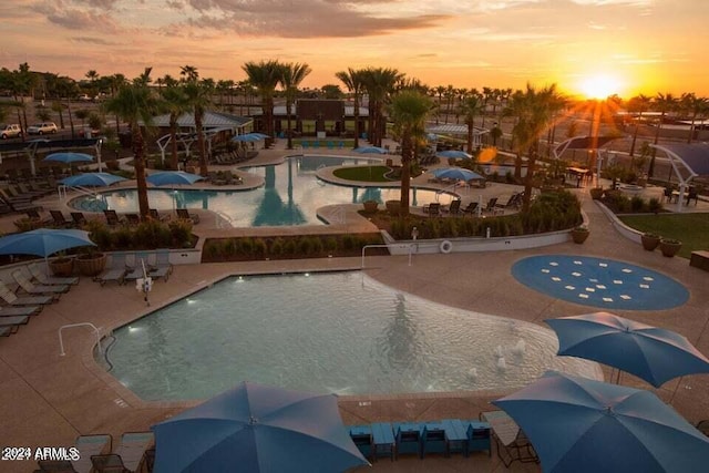 pool at dusk featuring a patio