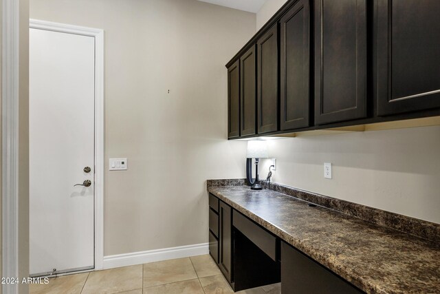 kitchen with dark brown cabinetry and light tile patterned flooring