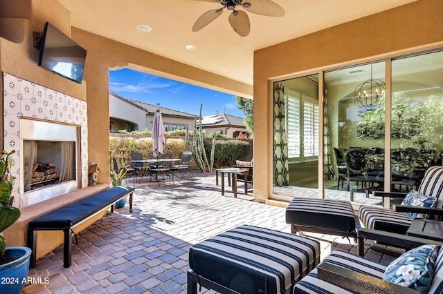 view of patio / terrace with an outdoor living space with a fireplace and ceiling fan