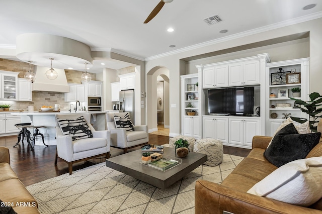 living room featuring sink, light hardwood / wood-style flooring, ceiling fan, built in features, and ornamental molding