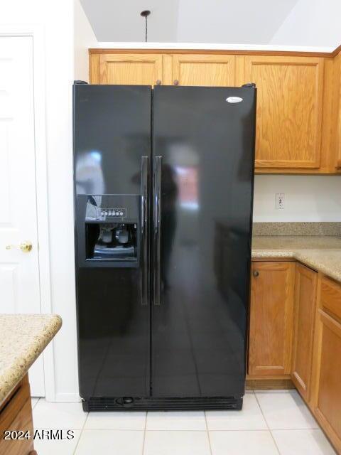 kitchen featuring light tile patterned flooring and black fridge