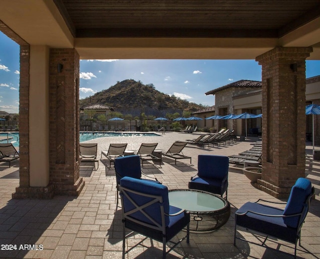 view of patio featuring a community pool and a mountain view