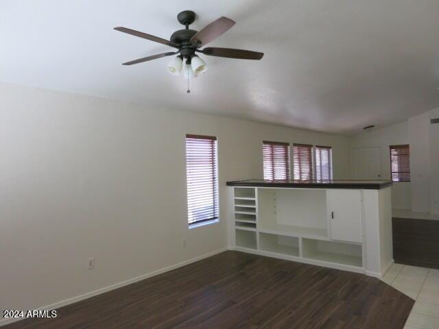 unfurnished living room featuring ceiling fan, hardwood / wood-style flooring, built in features, and lofted ceiling