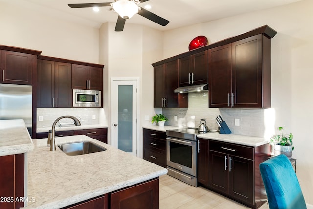 kitchen featuring sink, backsplash, a high ceiling, dark brown cabinetry, and stainless steel appliances