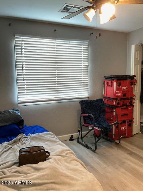 bedroom with multiple windows, ceiling fan, and light wood-type flooring