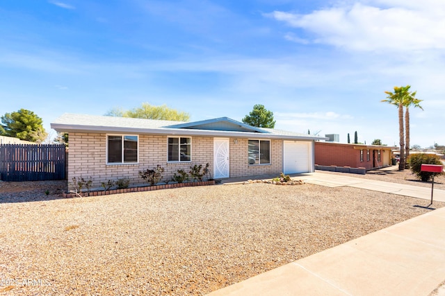 single story home featuring a garage, brick siding, concrete driveway, and fence