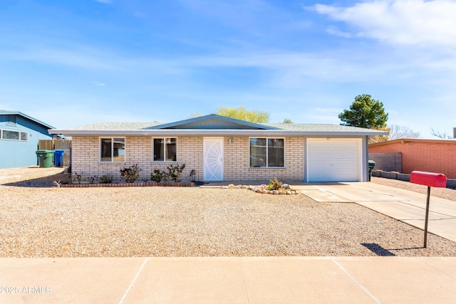 ranch-style home with brick siding, concrete driveway, fence, and a garage