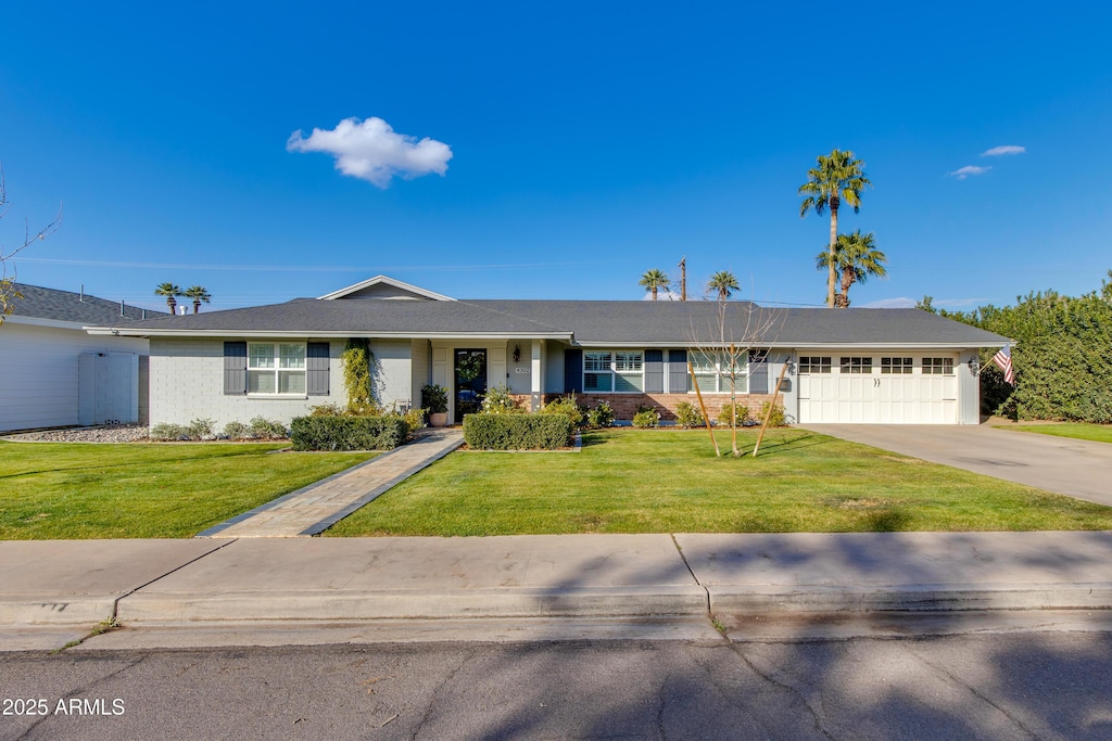 ranch-style home featuring a garage and a front yard