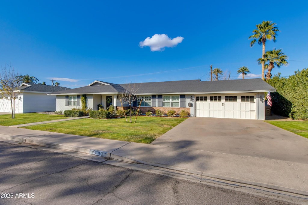 ranch-style house featuring a garage and a front yard