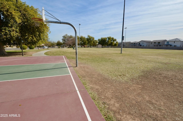 view of sport court with a lawn