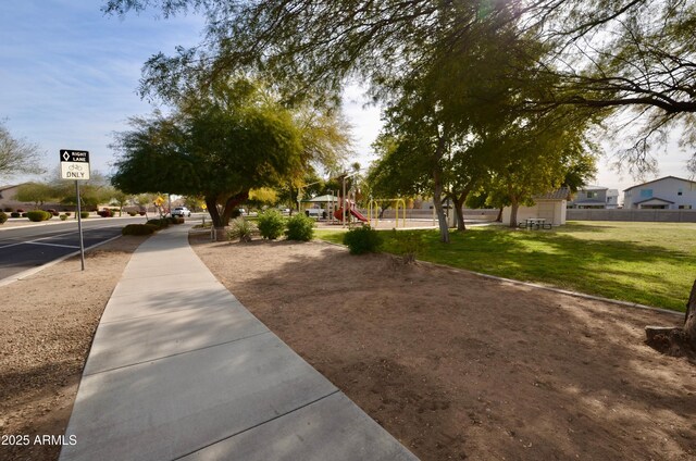 view of home's community featuring a playground and a yard