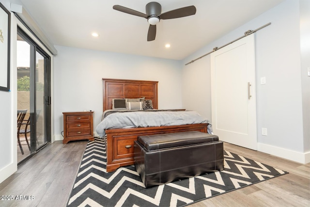 bedroom featuring access to outside, recessed lighting, light wood finished floors, and a barn door