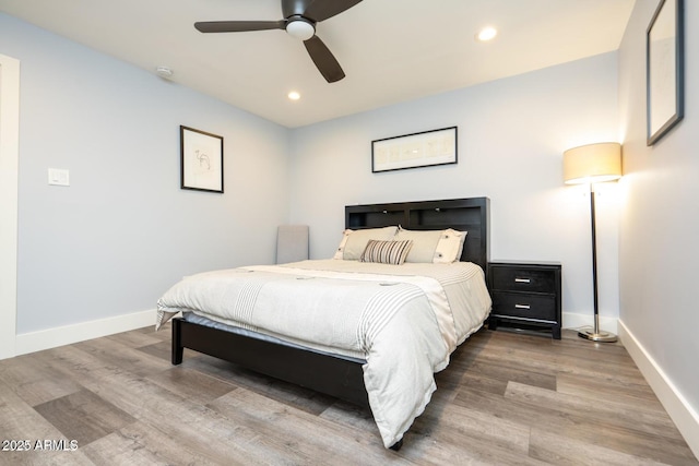 bedroom featuring baseboards, wood finished floors, and recessed lighting