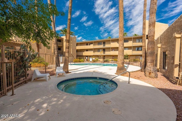 pool featuring a hot tub and fence