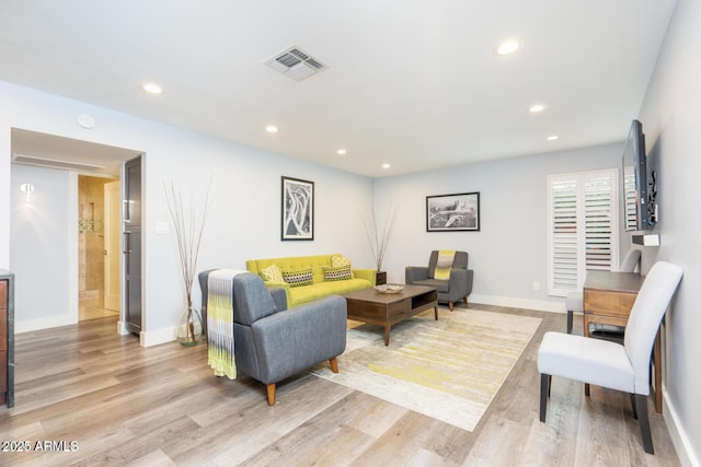 living area with light wood finished floors, baseboards, visible vents, and recessed lighting