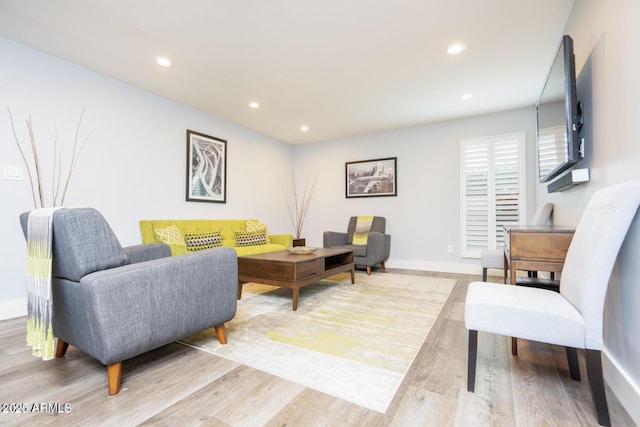 living room featuring light wood-style flooring, baseboards, and recessed lighting