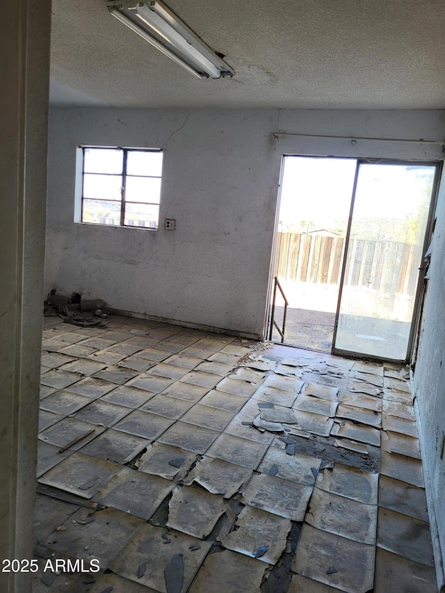 unfurnished room with a textured ceiling