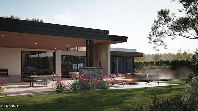 back of house featuring a patio, a lawn, and stucco siding