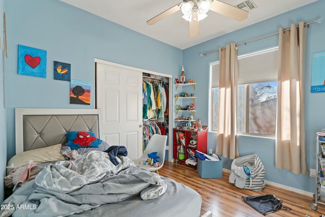 bedroom featuring wood-type flooring, ceiling fan, and a closet