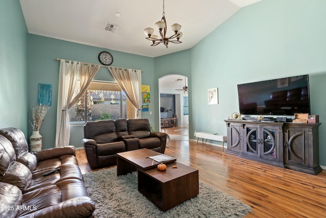 living room with lofted ceiling, hardwood / wood-style floors, and ceiling fan with notable chandelier