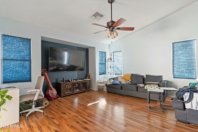 living room featuring hardwood / wood-style flooring, vaulted ceiling, and ceiling fan