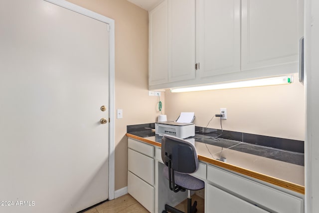 office featuring built in desk and light tile patterned flooring