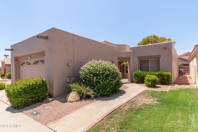 southwest-style home featuring a front yard and a garage